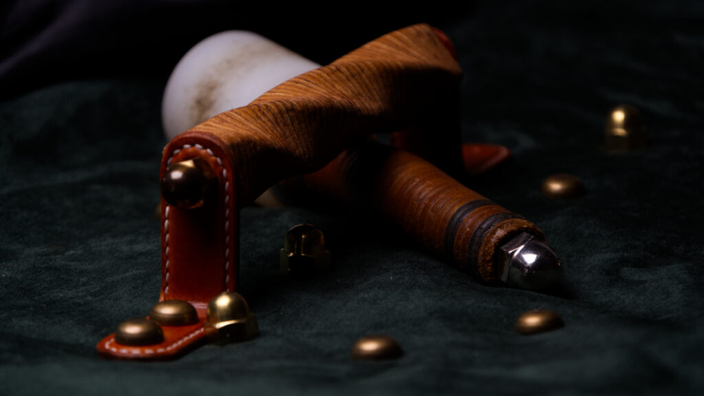 Stacked leather handles on dark background